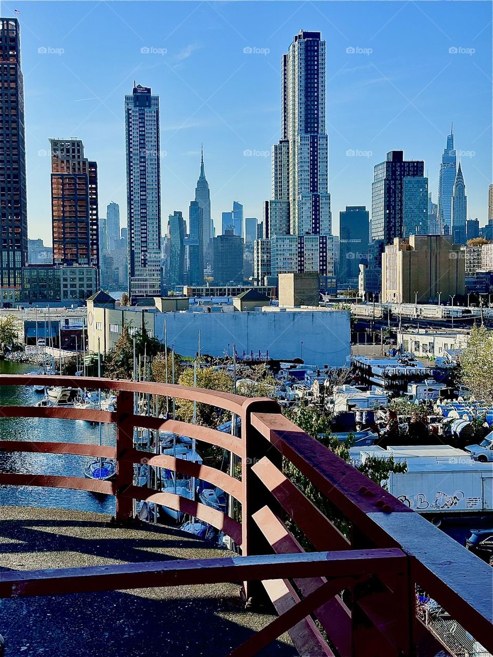 This is the phenomenal view from the pedestrian outpost on the „Pulaski Bridge“ at „Newtown Creek“ in LIC, Queens on a sunny Indian summer afternoon in early November 2023. „Manhattan“ and the „Empire State Building“ can be seen. Hypnotic Productions
