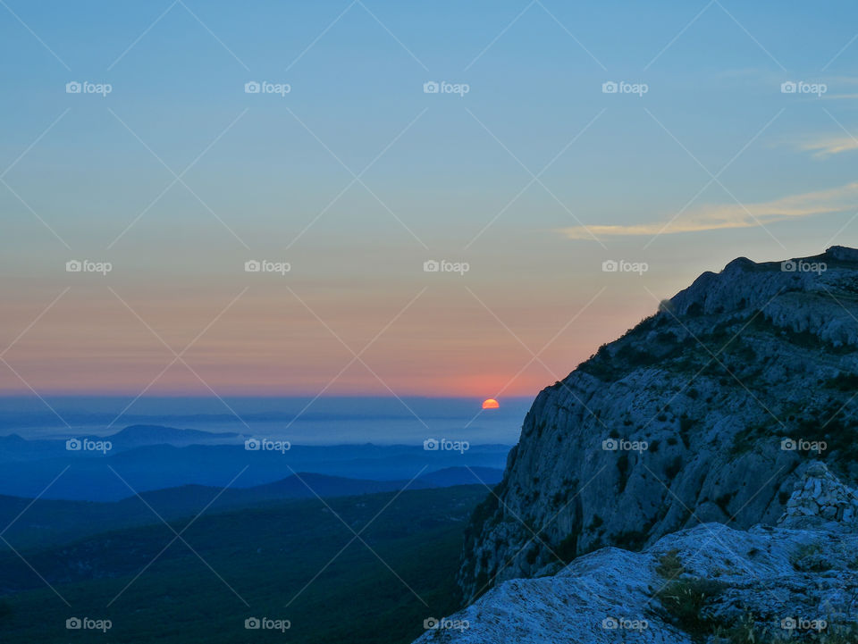 Sunrise on mountain in foggy weather