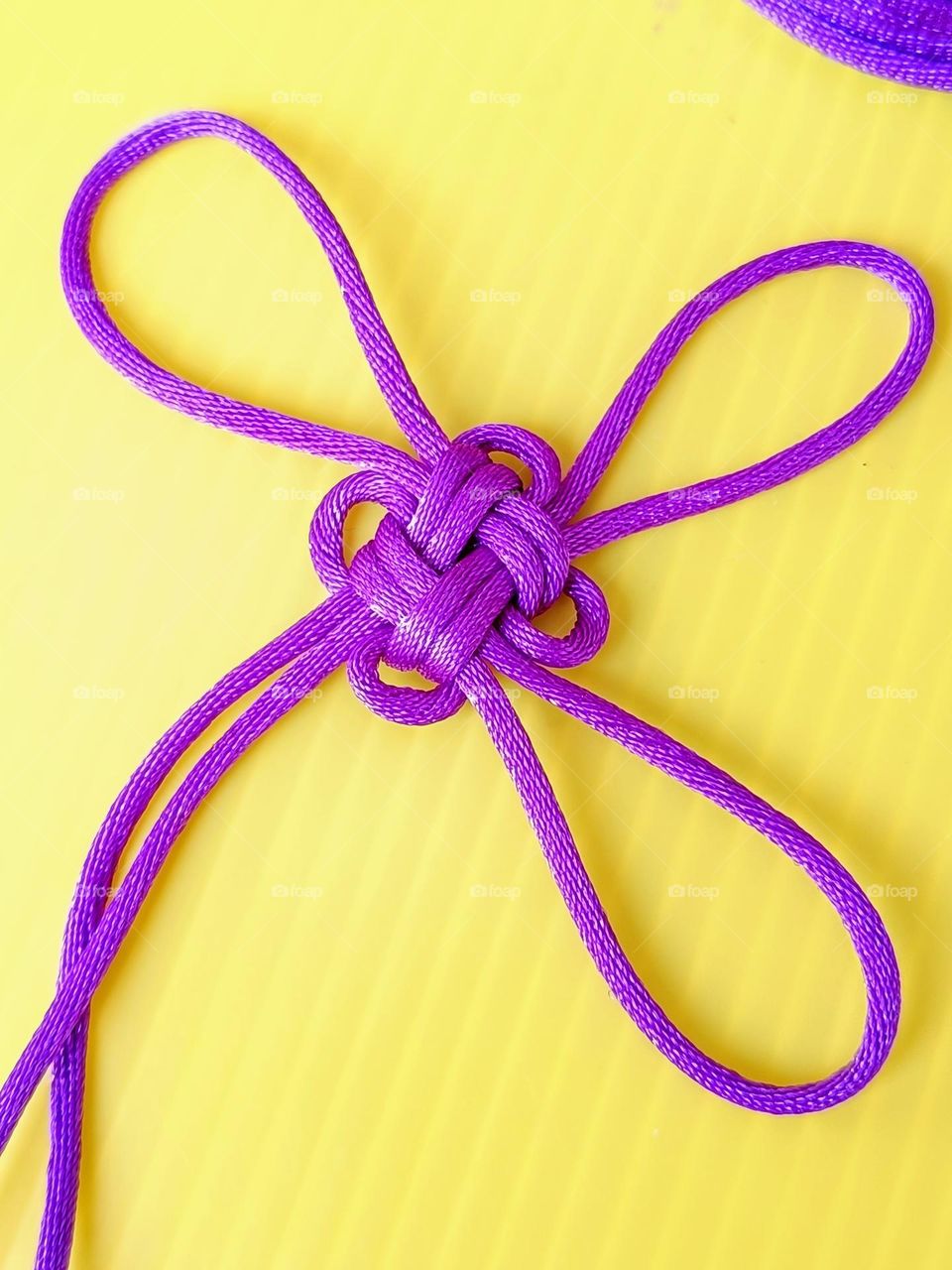 Chinese Good Luck Knot on yellow background.