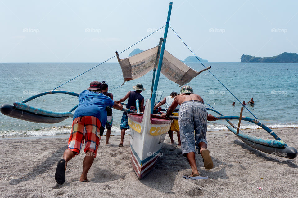 fishermen pushing a boat