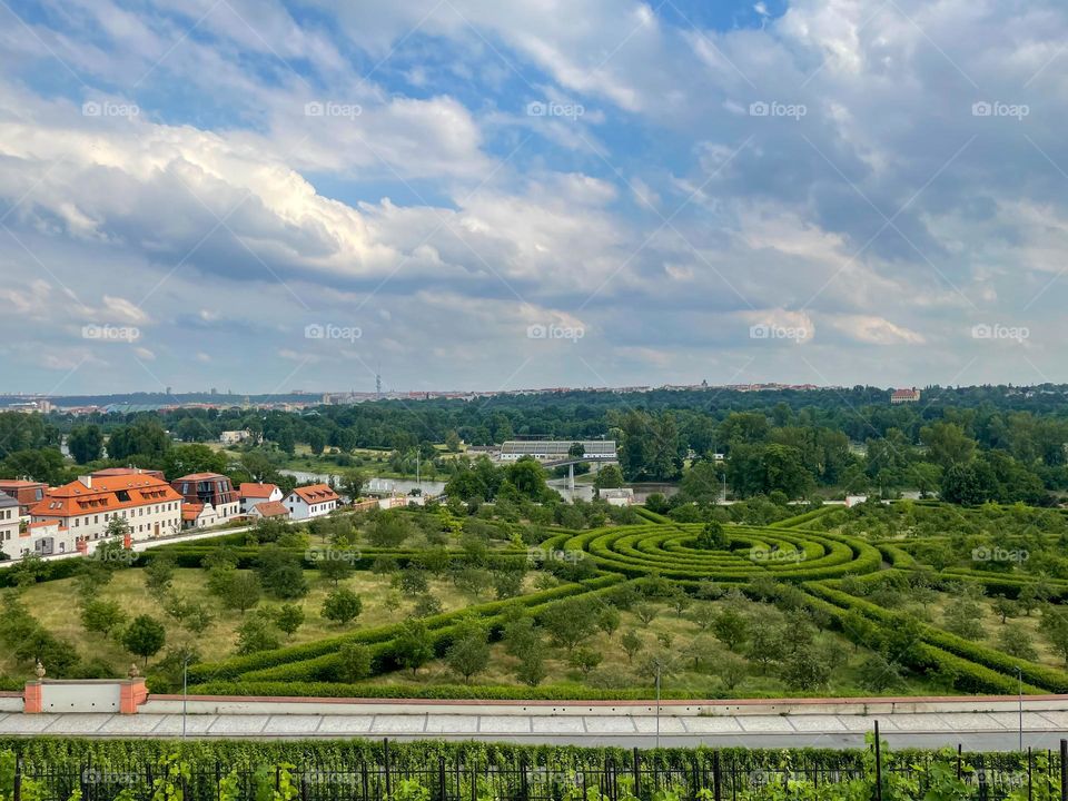 A circular hedge maze in the castle park near the castle in Prague Toji with a blue sky with clouds.