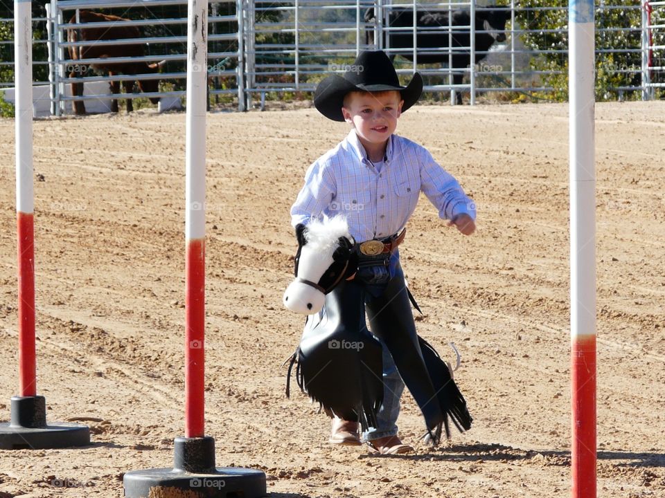 Little cowboy in a stick horse rodeo. 