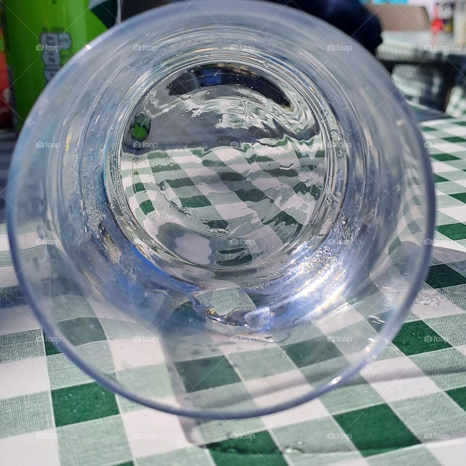 glass laying down on checked tablecloth. reflection