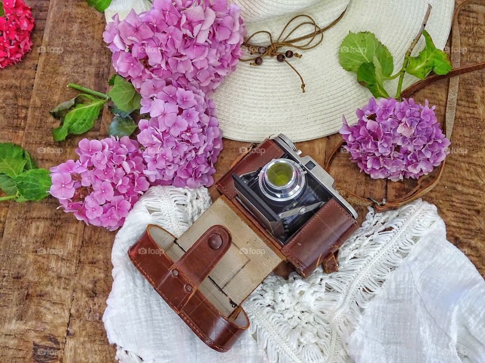 Still life with old camera and summer hat