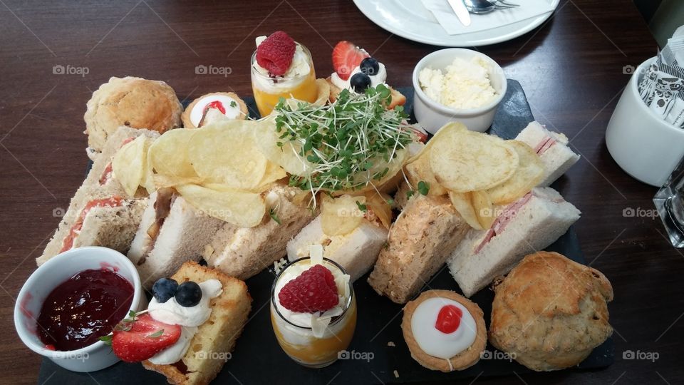 A lovely selection of delicious desserts and sandwiches for afternoon tea, accompanied by juicy fruits and salta crisps!