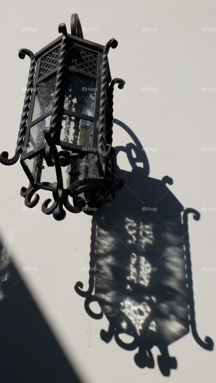 Light fixture casts shadow on an outside wall.