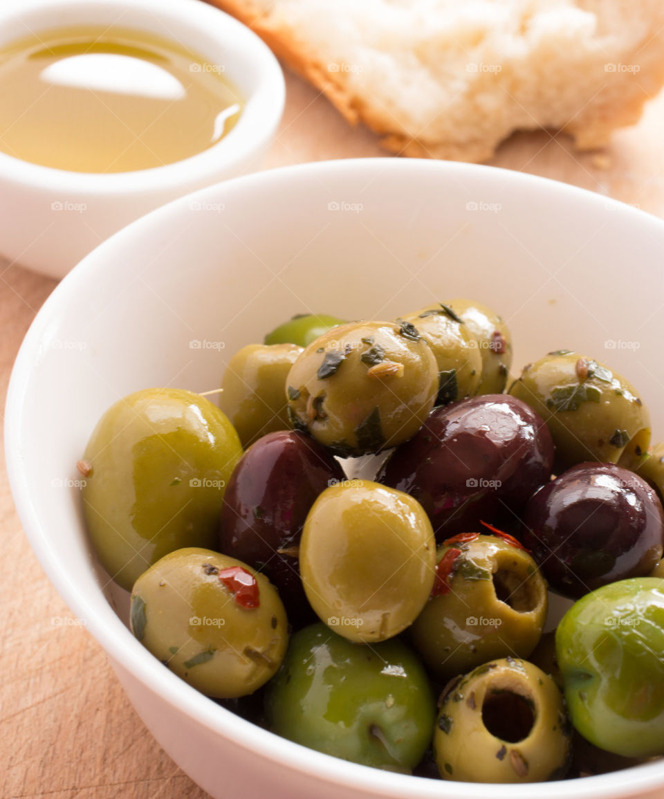 Bowl of olives with olive oil. Bowl of mixed olives with olive oil in a bowl and white bread