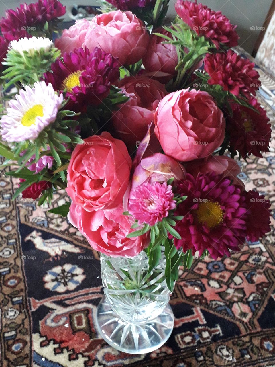 autumn flowers bouquet in cristal vase on the table