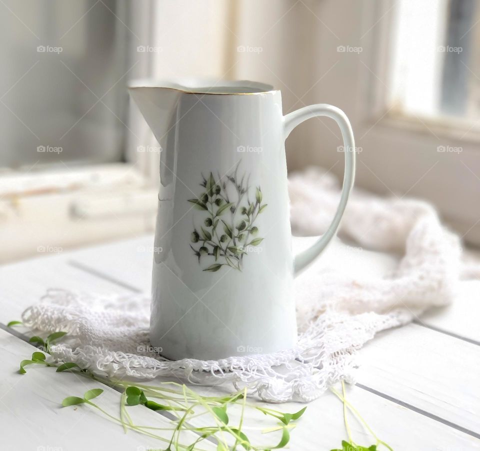 Old porcelain creamer with handles and green olive ornaments