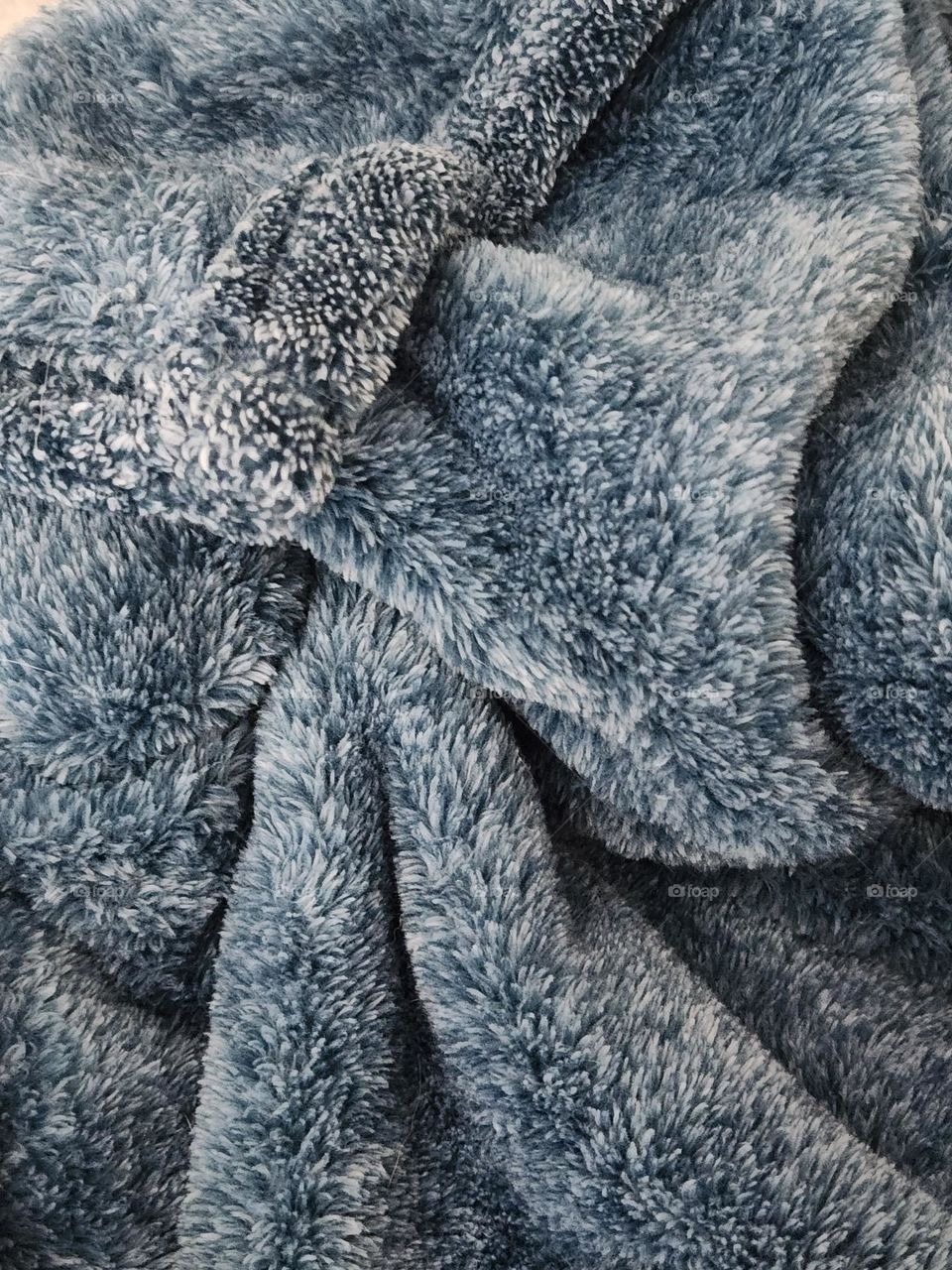 close up of a cozy blue gray plush comfort blanket to curl up in at home