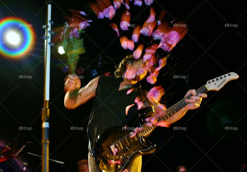 Signature move . Strumming his guitar with a bunch of roses - musical instrument mission