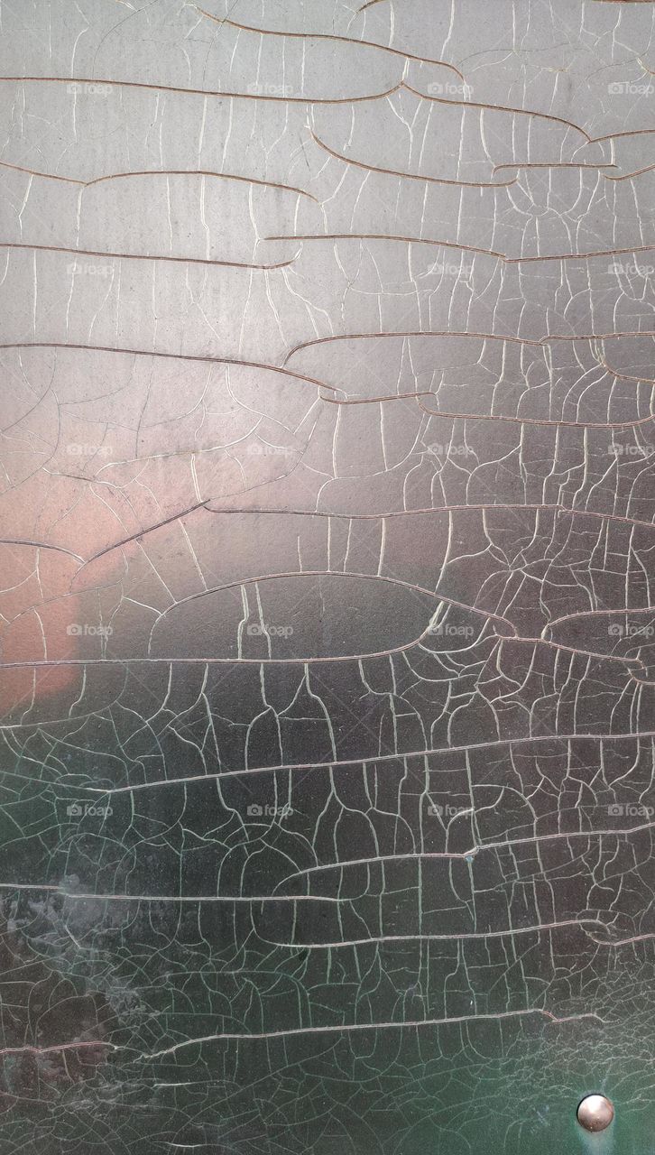 Cracked painting with sunset reflection on the texture