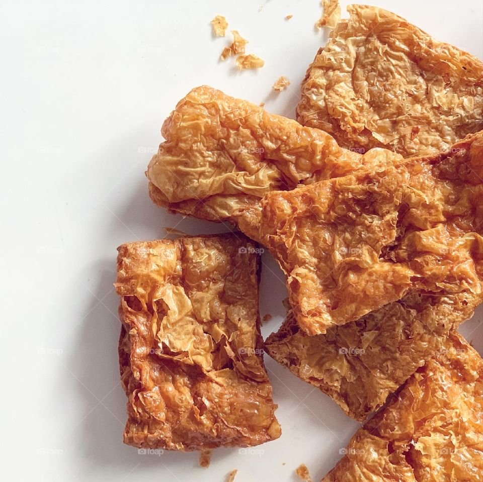 Vegetarian mock goose meat also known as soy crisps in golden hues flat lay