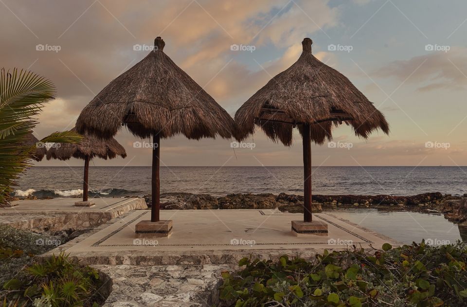 Couple of umbrellas by the sea at sunset: A place of Peace and Relax in Mexico in Puerto Aventuras.