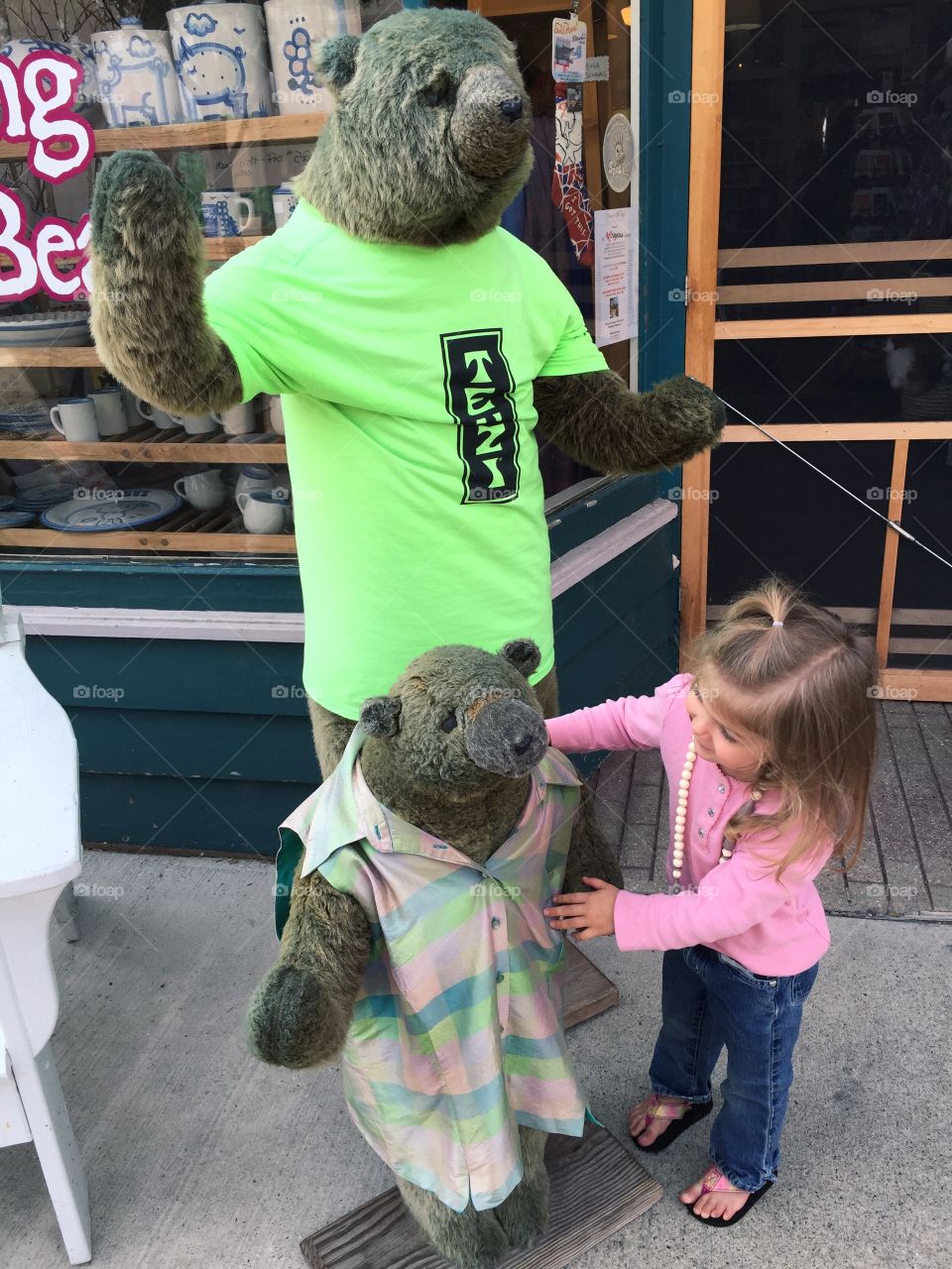 Cute girl standing near bear sculpture