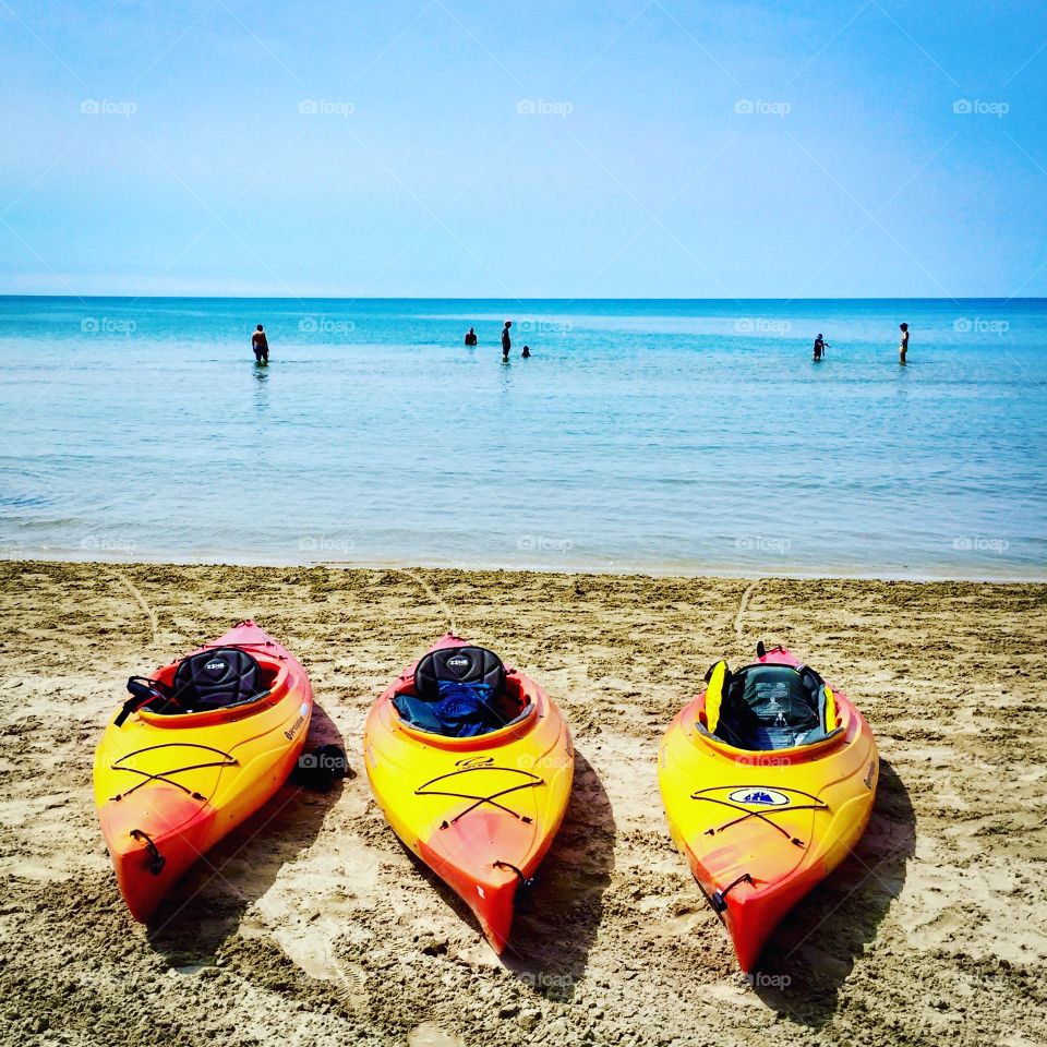 Three Kayaks on the lakeshore at Wasaga beach. Travel to Ontario, Canada !