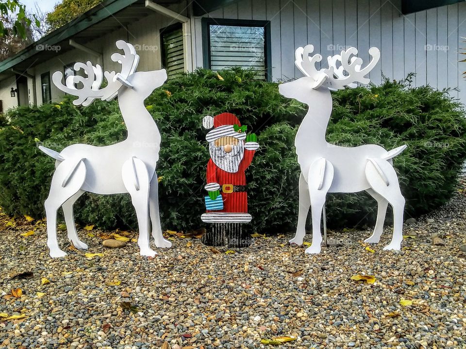 metal santa claus between two white deer decoration