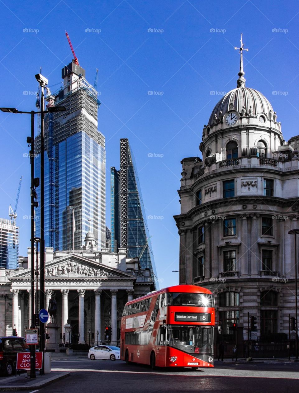 City of london. Financial district. Red bus in front of old buildings. Skyscrapers in the bakground.