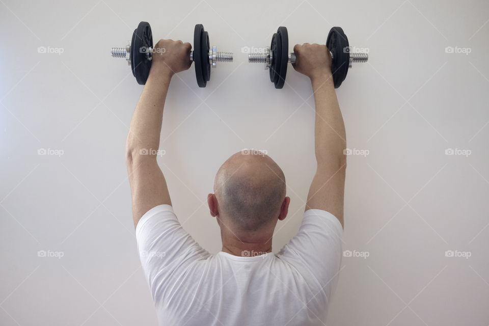 Man does the weights to keep himself in training every week