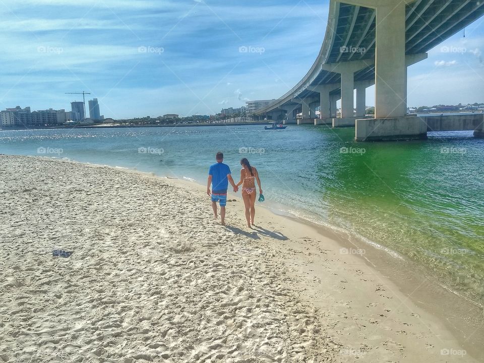 man and woman waking on the beach