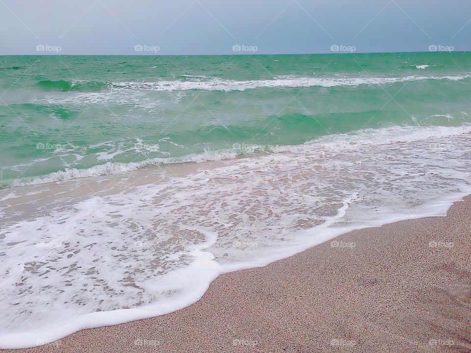 Beautiful green water and white surf on the beach.