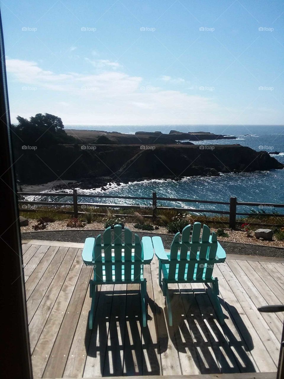 Blue chairs facing sea