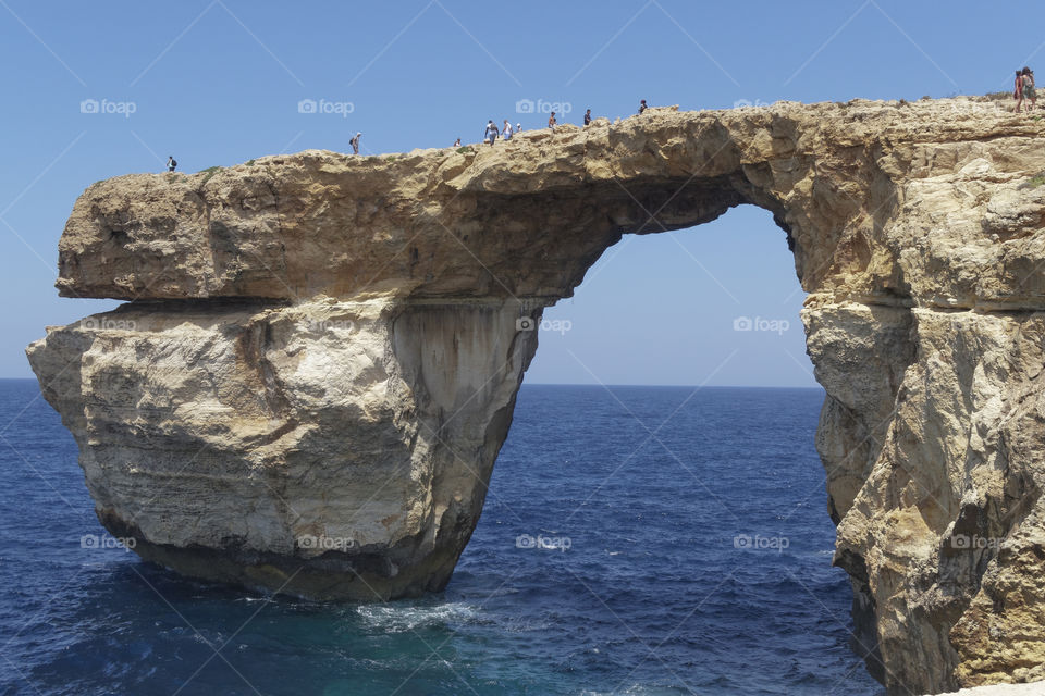 Gozo Island, Malta Azure window tourists on the cliff.
Azureus window was in danger of collapsing. It finally collapsed on March 08 2017 after being hit by heavy storms.