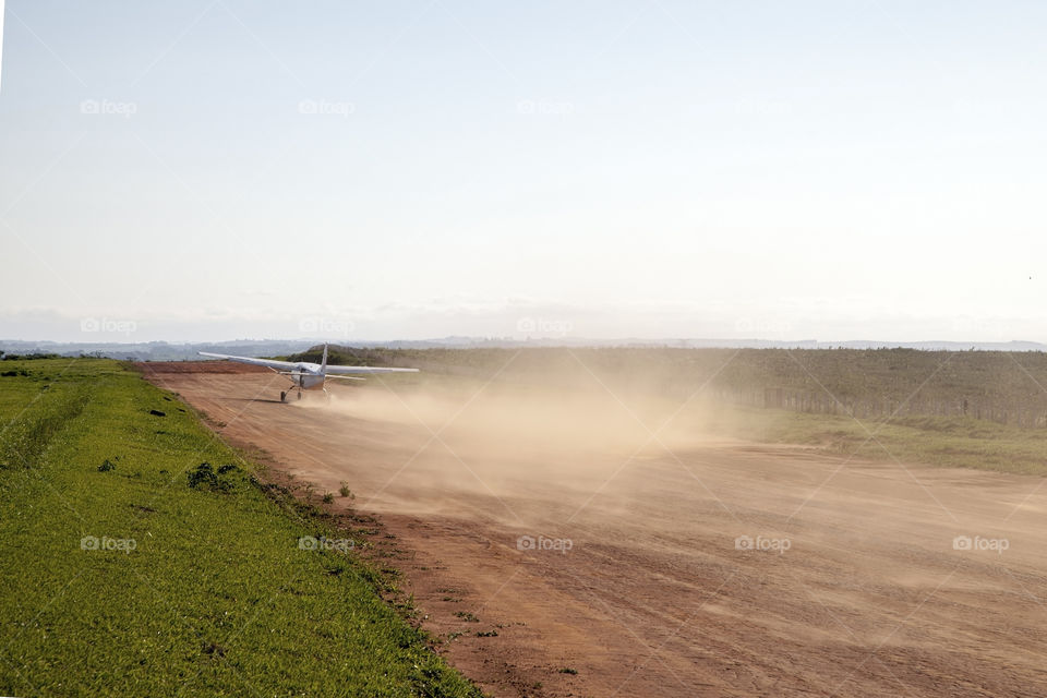 airplane taking off on a dirt runway