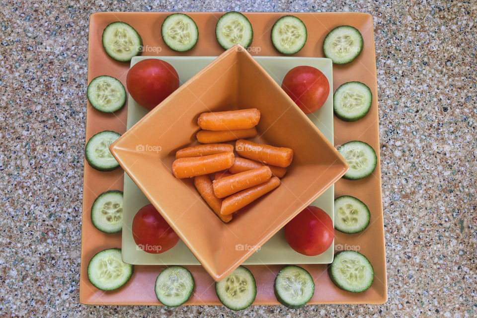 Veggie plate with carrots, cucumbers, and tomatoes.