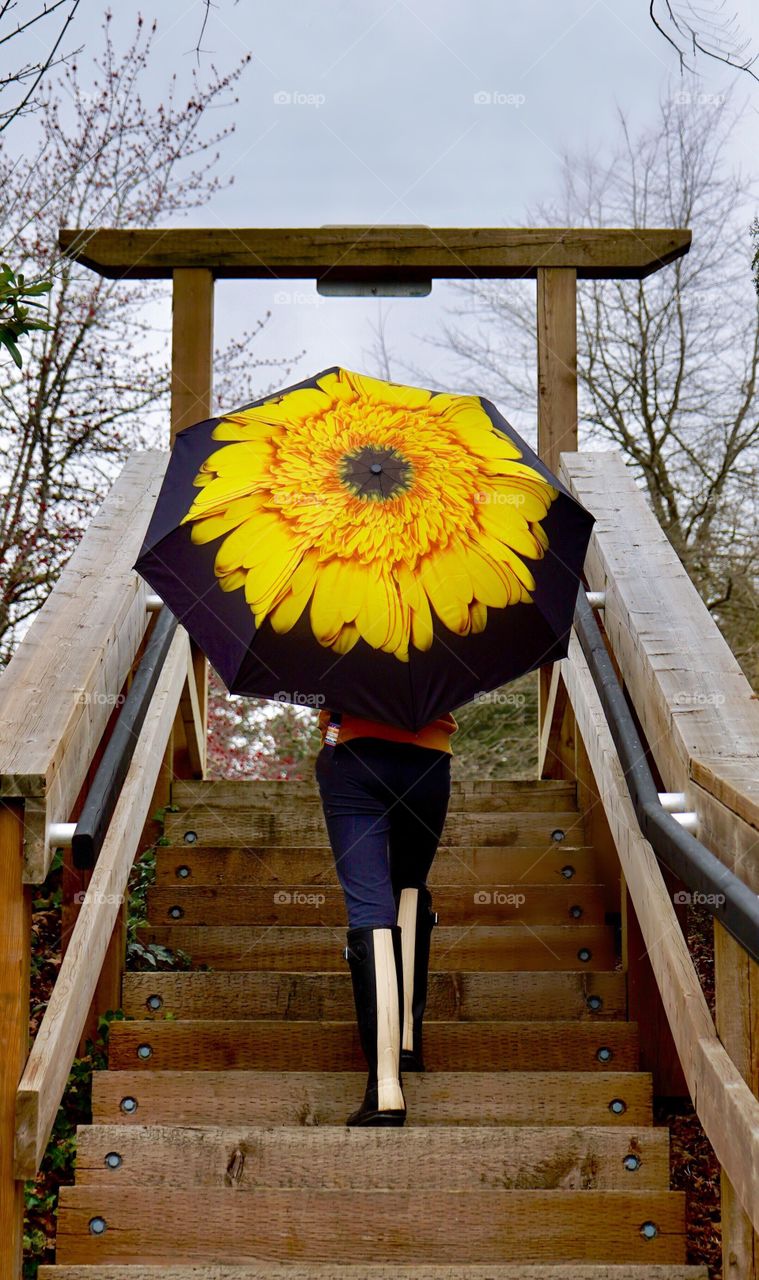 Girl walking up outdoor staircase with flower umbrella 