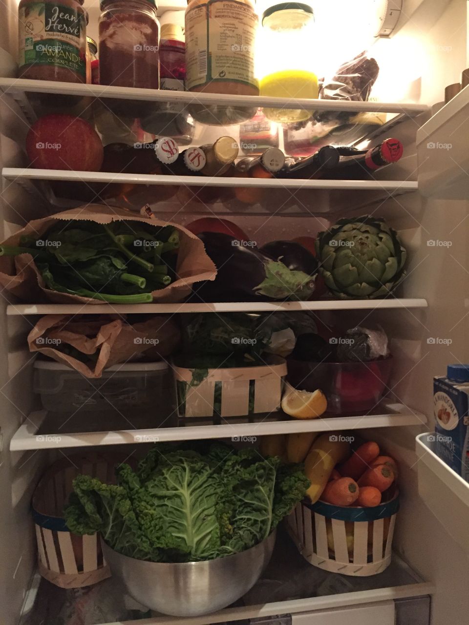 Healthy stocked fridge full of whole foods, vegetables and fruits