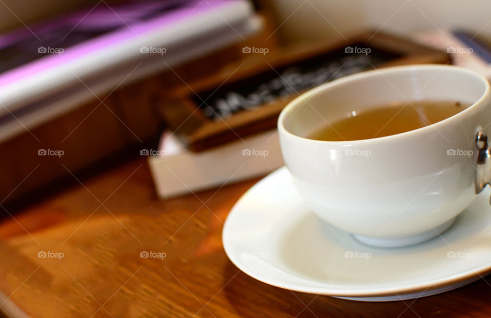 Cup of tea on wood table with books conceptual lifestyle background 