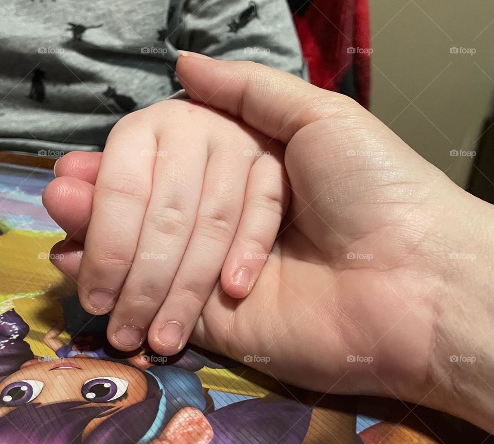 Young 7 yr old girl holding grma hand, sitting at the table during supper