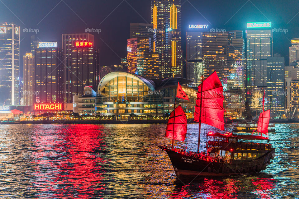Hong Kong night cityscape with Aqua Luna boat at Victoria harbour