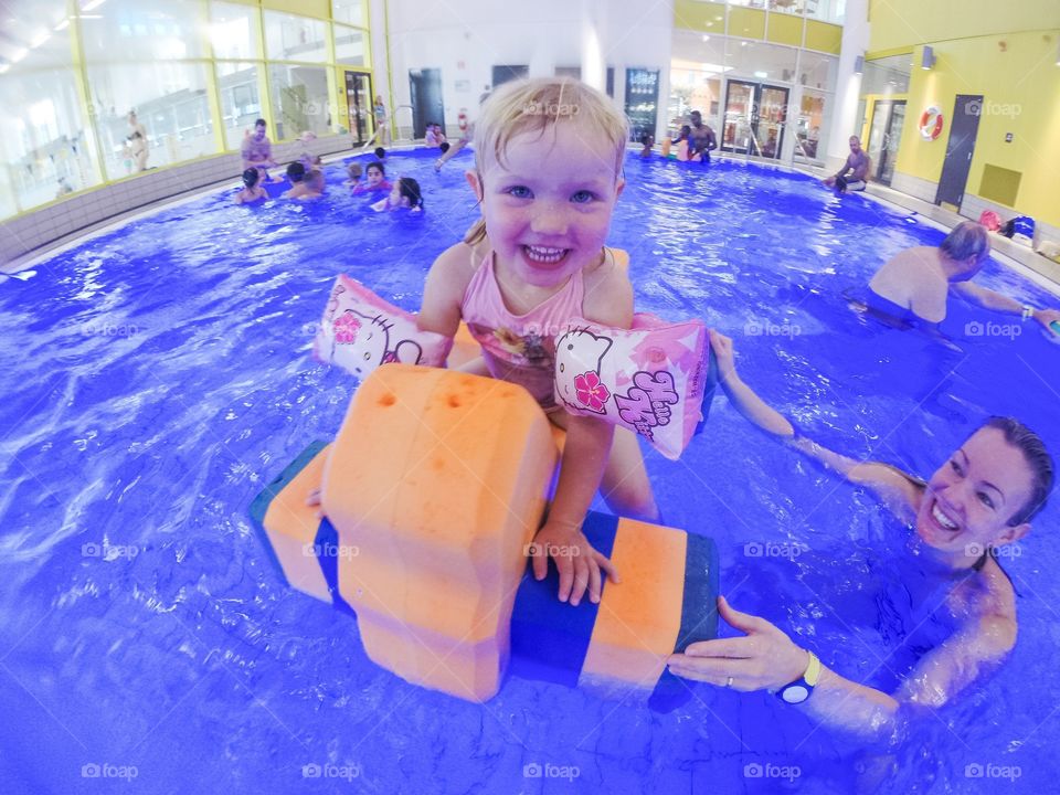 Family playing in the pool at a local baths in Sweden.