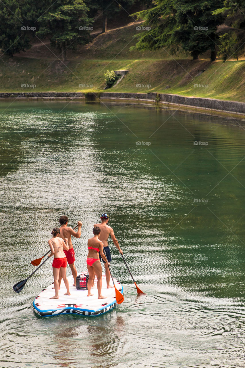 Couples Rafting At The Lake Park On Vacation In Summertime