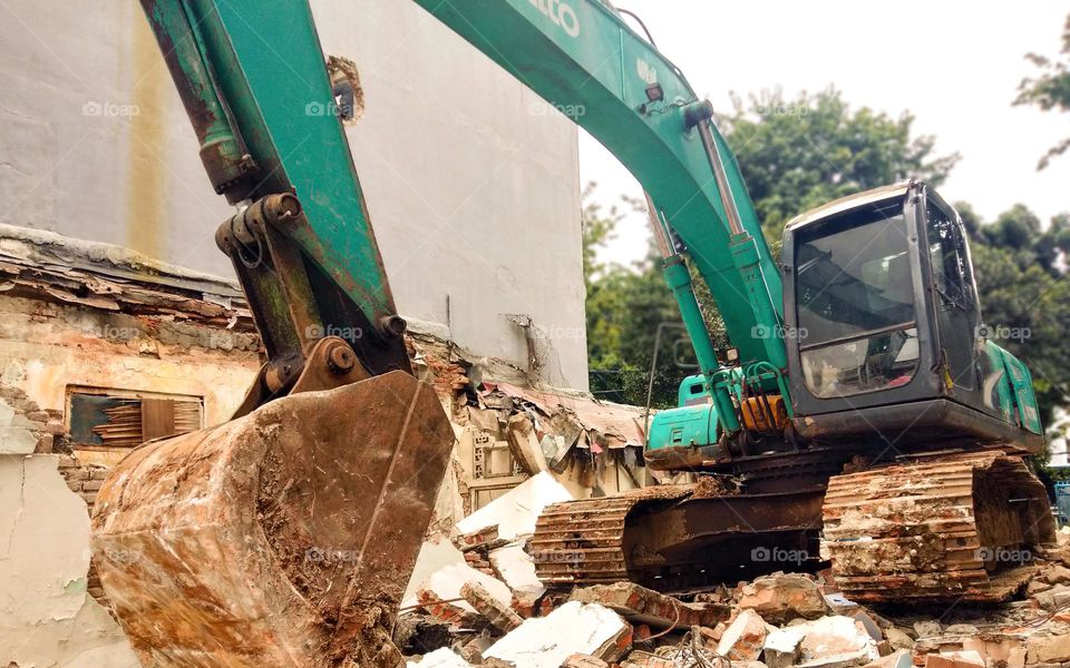 Photo of tractor or heavy vehicle destroying buildings