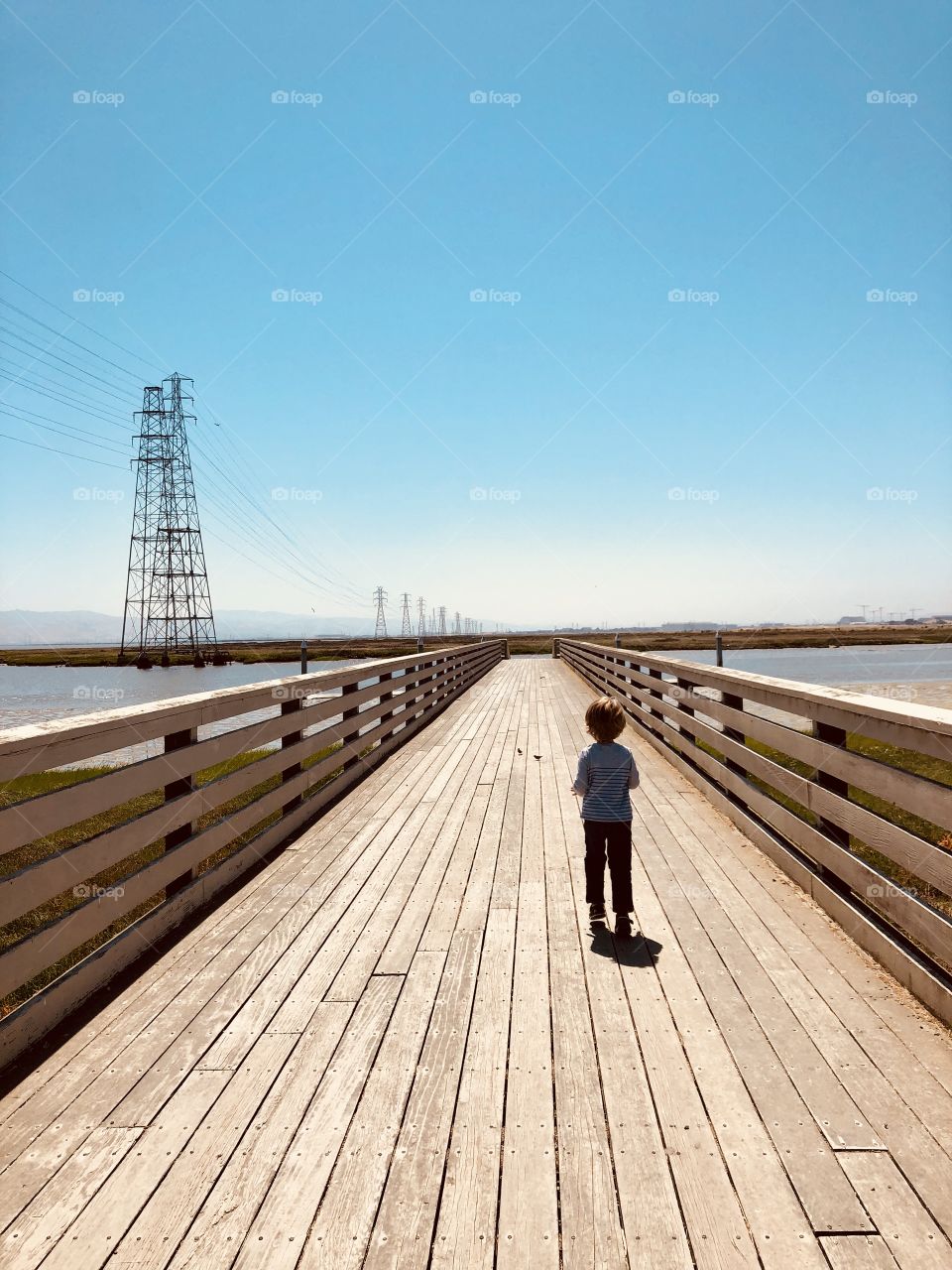 Boy walking on the long bridge 