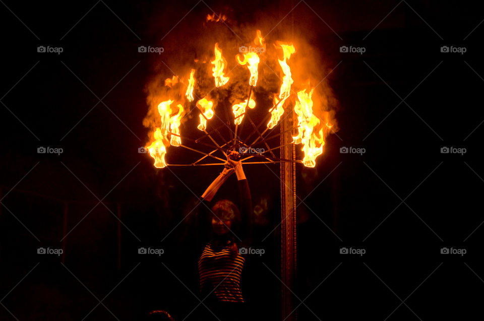 Fire performance during the night, young girl dancing with fire 