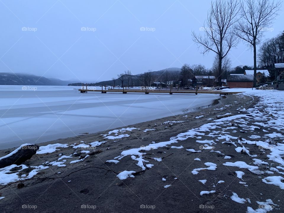 Snow melts on Lake george in Spring