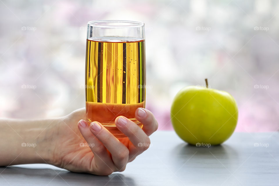 Close-up of human hand holding glass of juice