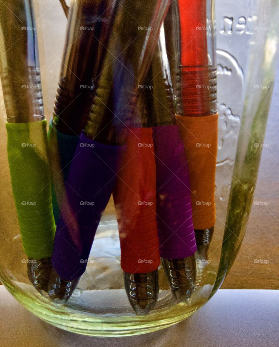 Closeup of colorful pens in glass jar 