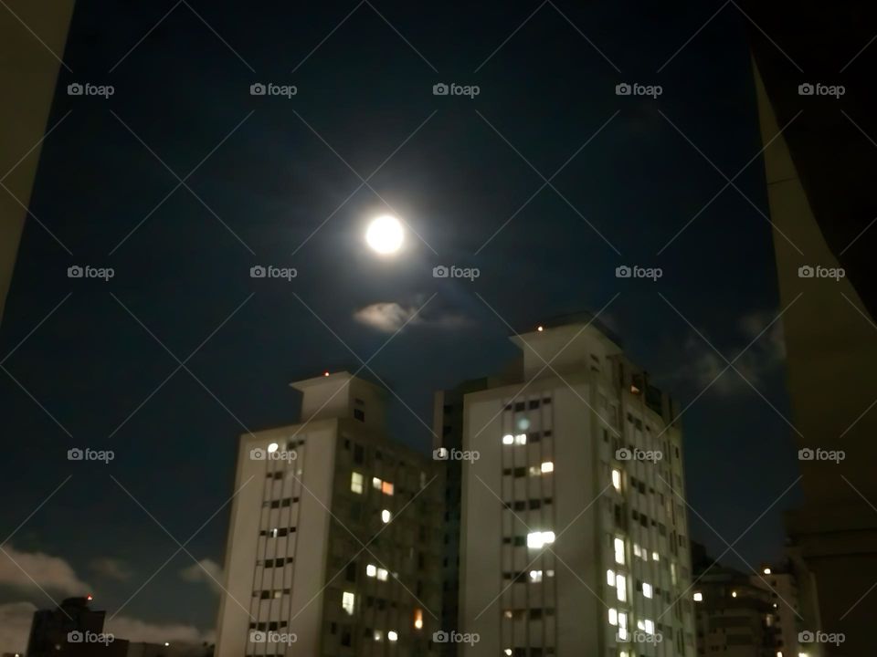 Two buildings illuminated by the full moon