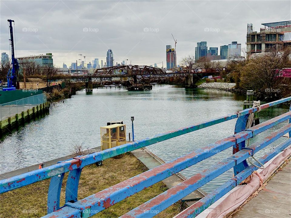 This is the “Borden Avenue Bridge” over “Dutch Kills”, an ocean inlet of the “East River” in LIC, Queens on an overcast day in December 2023. The arched structure across the water is an old railroad bridge. Hypnotic Productions
