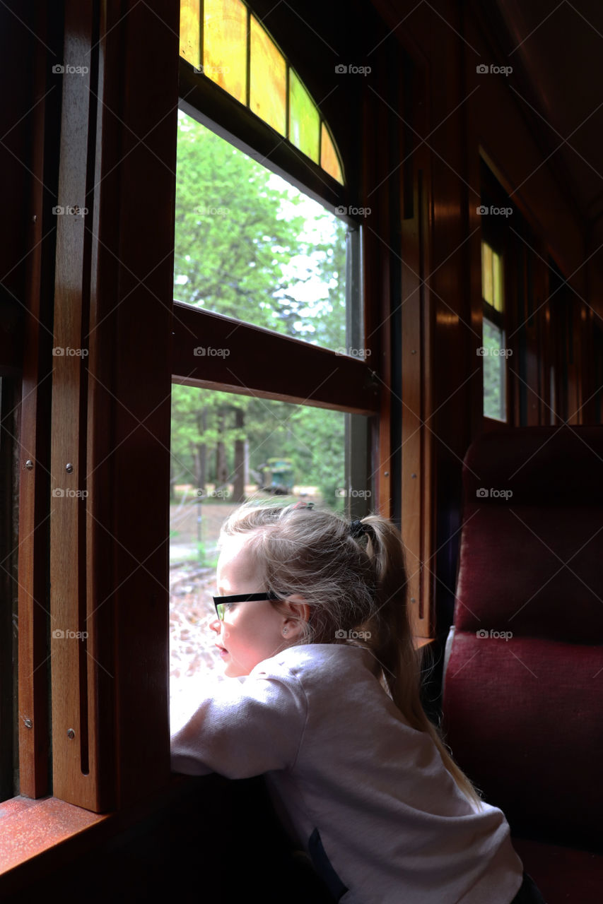 Young girl looking out a train window