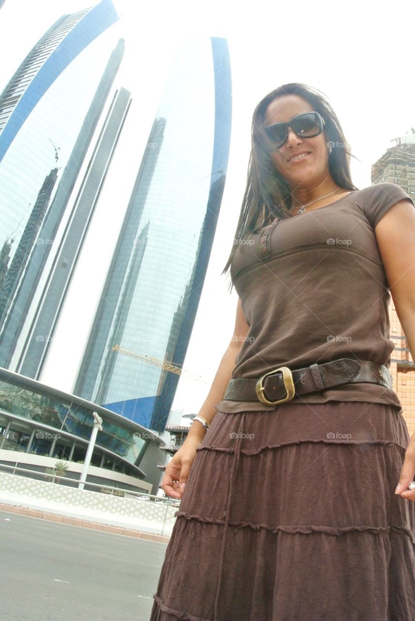 Woman wearing sunglasses against skyscraper