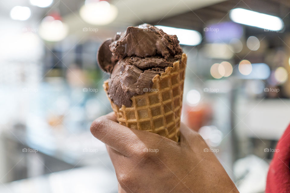 Person's hand holding waffle cone