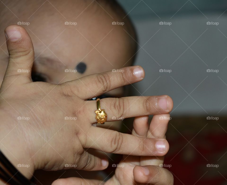 Innocent baby girl looking at her ring