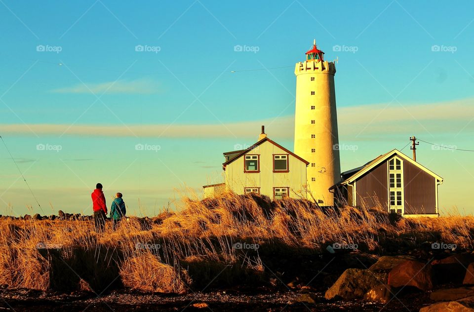 Two people standing in front of lighthouse