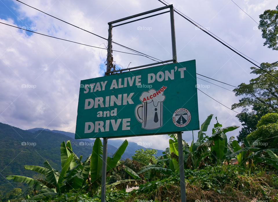 Portland Parish, Jamaica - January 1, 2014: Green Don't drink and drive road safety sign by the side of the B1 road in the Blue Mountains region of the Portland Parish, Jamaica on New Years Day morning 2014 issued by the National Road Safety Council.